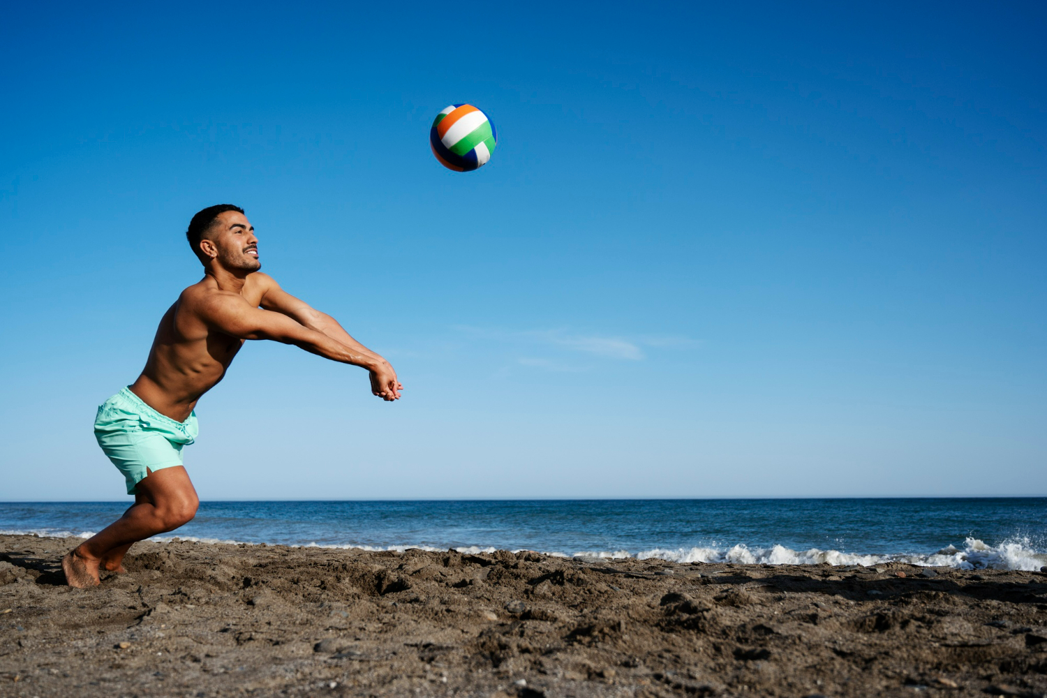 homem jogando esportes na areia volei de praia
